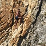 Climbing barefooted up the side of the cliff