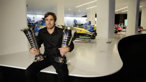 Alonso holding his two F1 world championship trophies 
